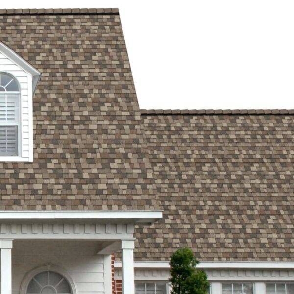 House with brown shingle roof, white trim, and a small tree in front.