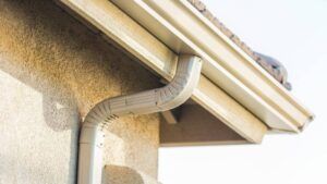 Tan gutter system on a stucco house exterior.