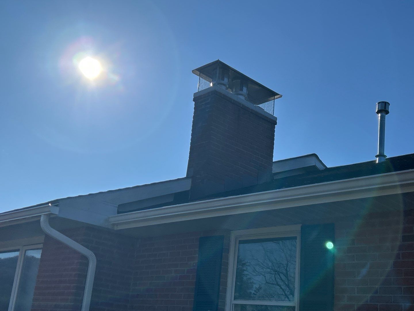 Brick chimney with newly repaired roof flashing on a residential home on Fairway Drive in Jonestown, PA.