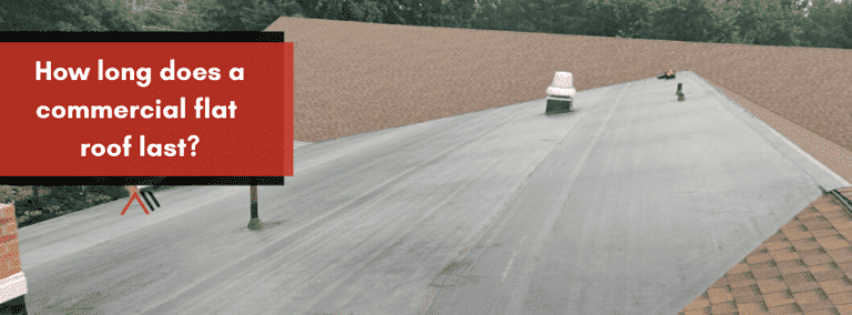 Red sign with white text asking, “How long does a commercial flat roof last?” on a building roof.