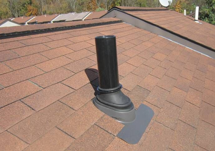 Black plumbing vent pipe on a brown shingle roof.