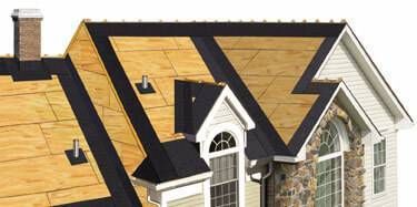 Close-up of a house roof showing plywood sheeting and a black underlayment.