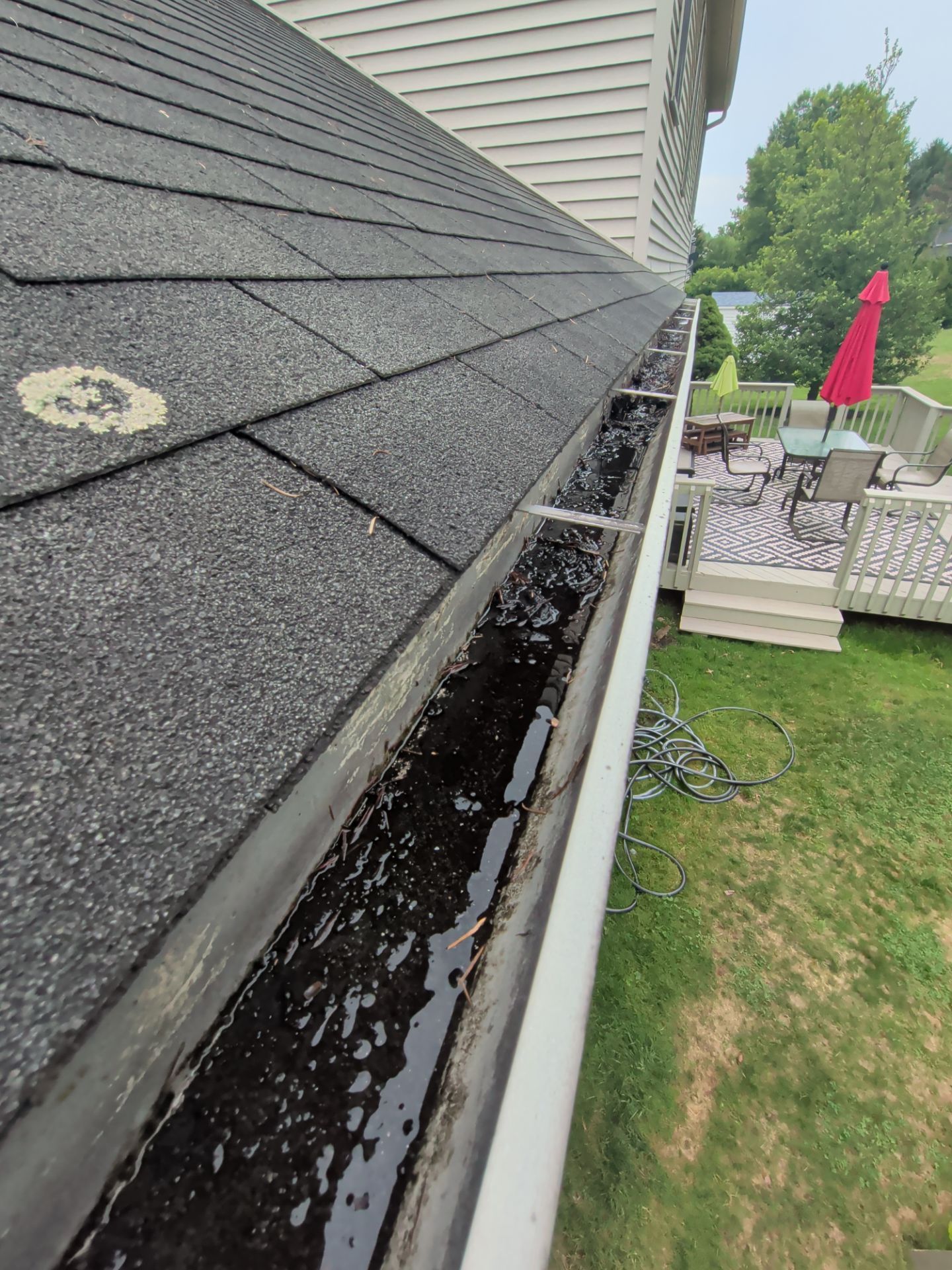Clogged residential gutter filled with standing water during a roof and gutter inspection on South Maurice Street.