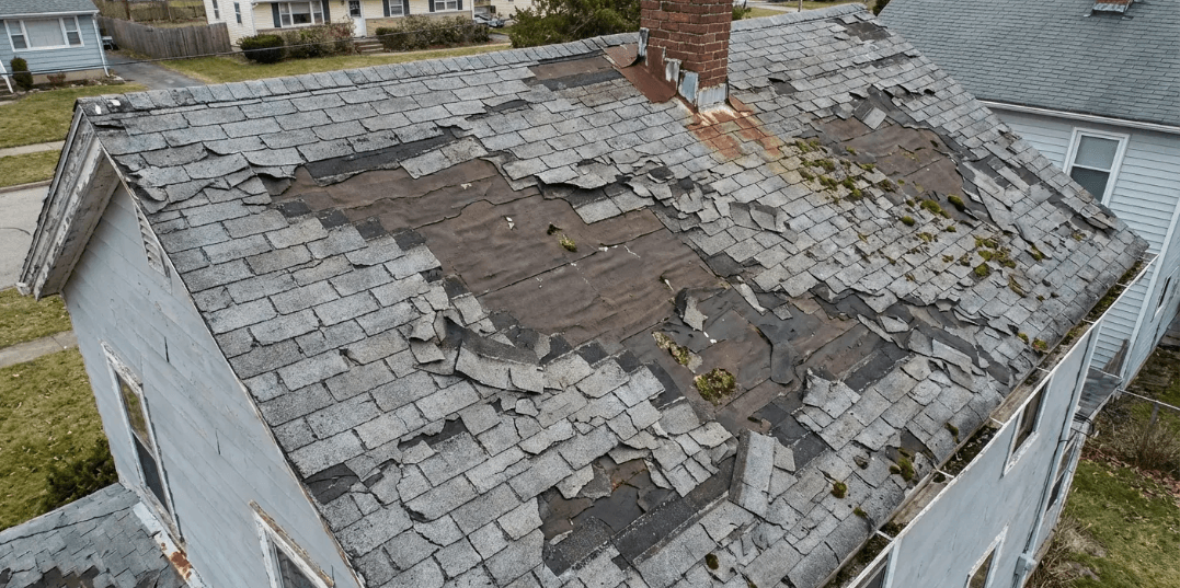 Severely worn asphalt shingle roof with missing and damaged sections showing when treatments fail in roof maxx reviews
