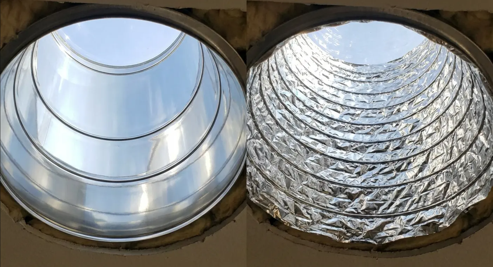 Two circular ducts, one smooth metal, the other flexible, looking up towards the sky.