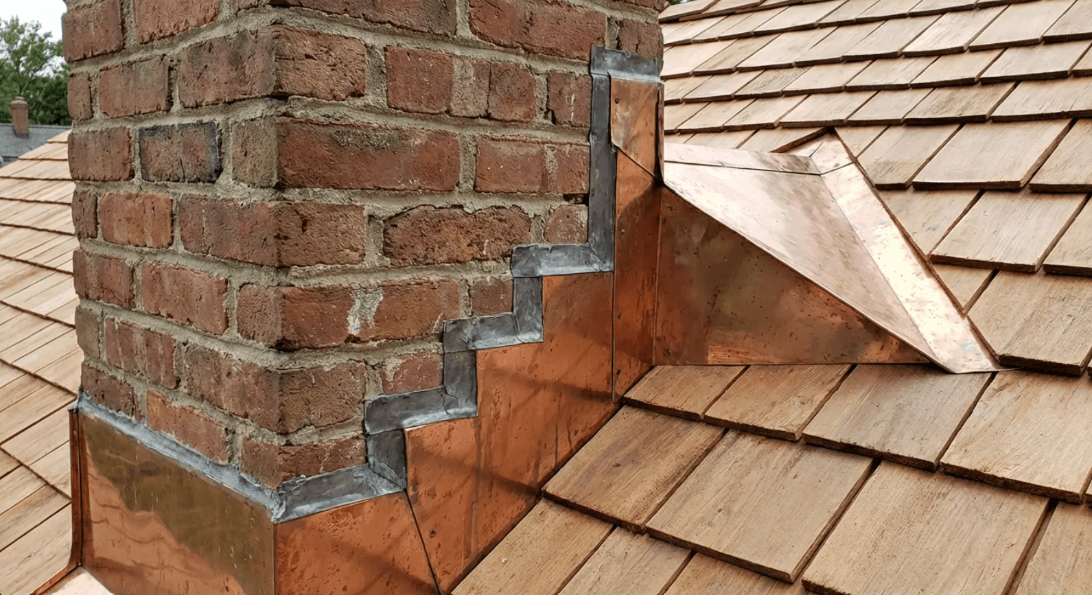 Copper flashing at a Cape Cod chimney junction - where different types of houses demand different waterproofing standards