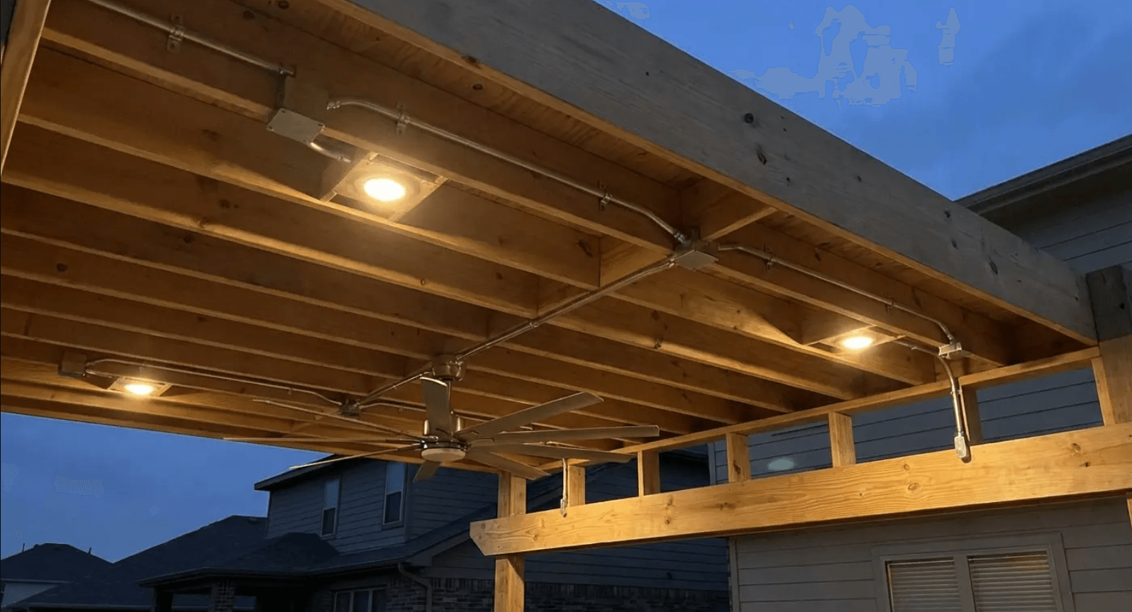 Underside of a timber patio roof at dusk with recessed lighting installed, showing electrical integration done right from the start