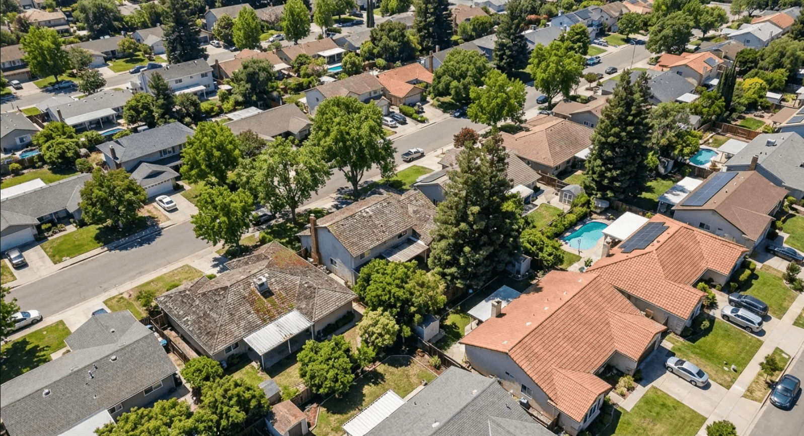 Aerial view of a neighborhood where maintenance history - not age - determines which roofs need replacing first
