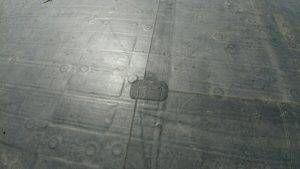 Overhead view of a dark, patterned surface with raised rectangular feature at the center.