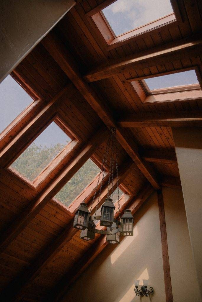 Angled wooden ceiling with skylights, chandelier.