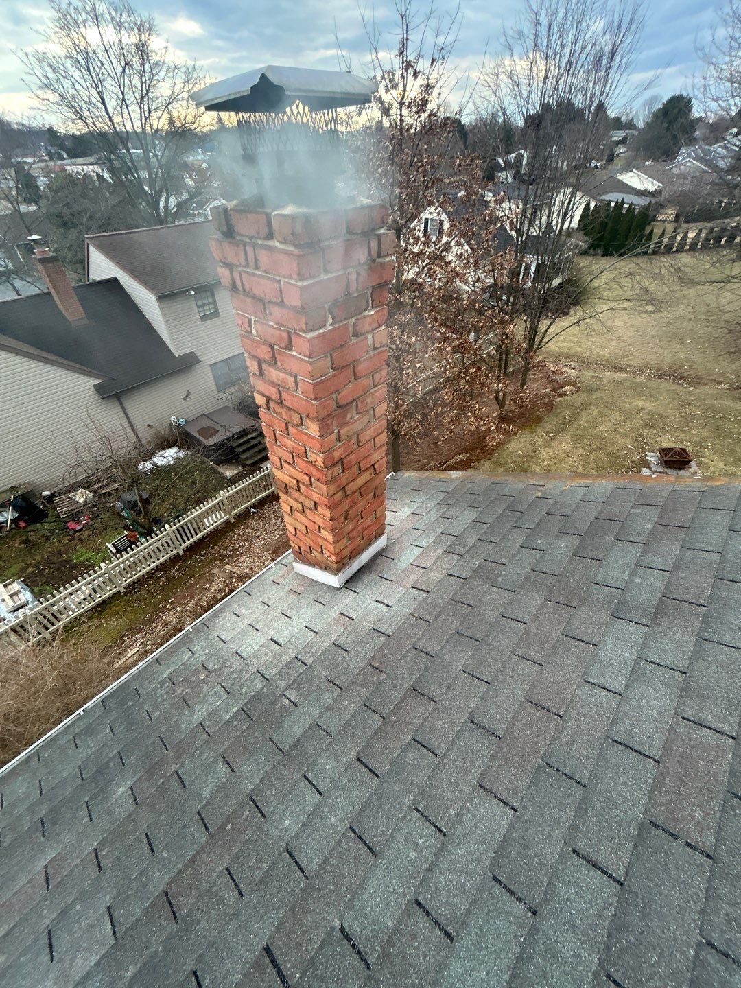Completed asphalt shingle roof replacement with chimney flashing on Swatara Circle in Jonestown, PA.