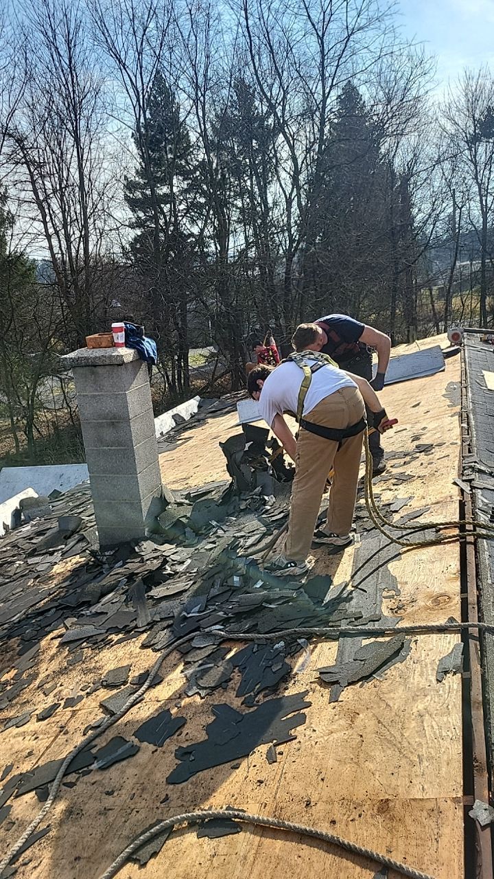 Roofing crew removing old asphalt shingles and preparing the roof deck for a replacement on Yingst Drive in Jonestown, PA.
