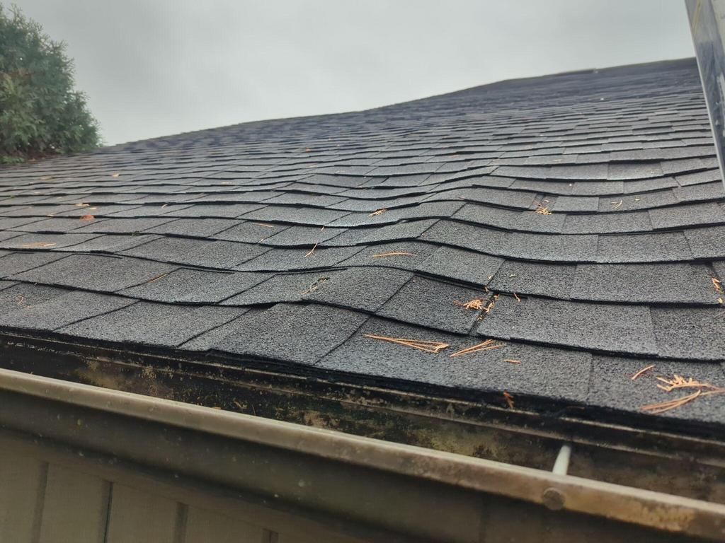 Close-up view of worn and uneven asphalt shingles on a residential roof in York, PA, showing signs of aging and weather-related roofing damage inspected by Joyland Roofing.