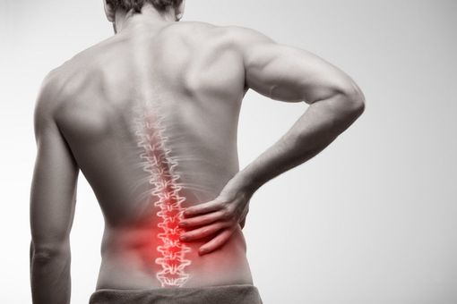 A man is holding his neck and back in pain.