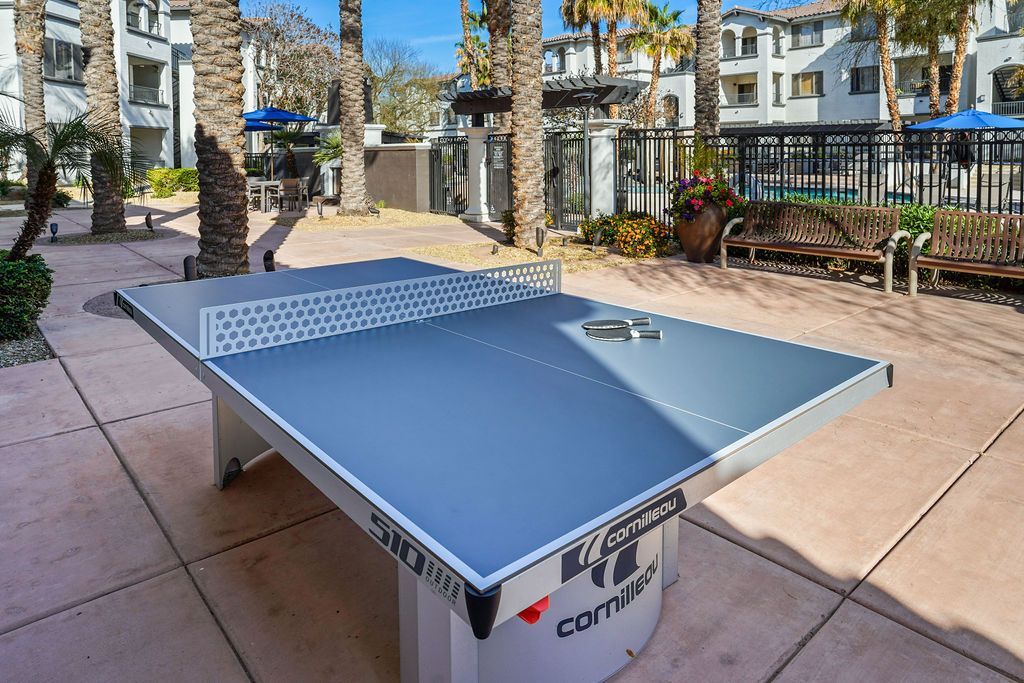 Outdoor communal courtyard with a ping-pong table and benches.