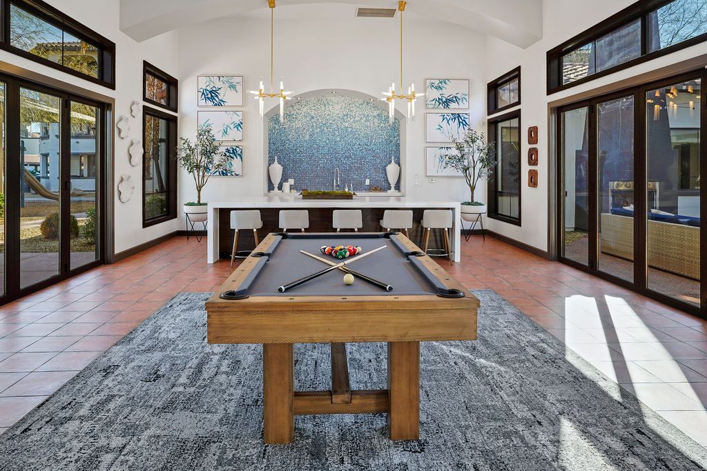Bright indoor community lounge with a pool table and bar seating.