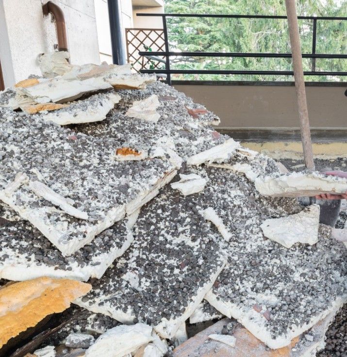 Person applying spray foam insulation to a wooden wall.
