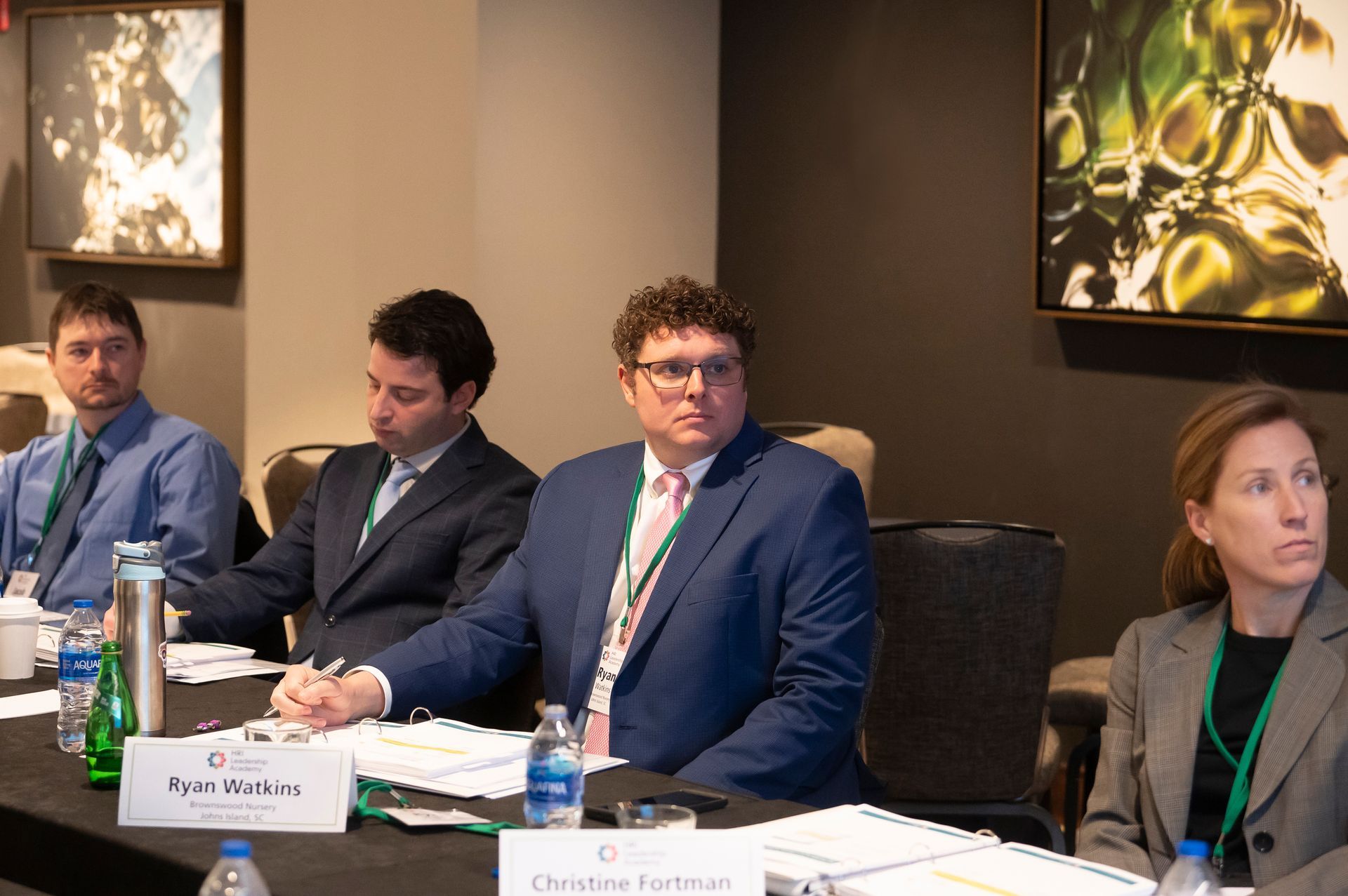 a group of people are sitting at a table in a conference room .