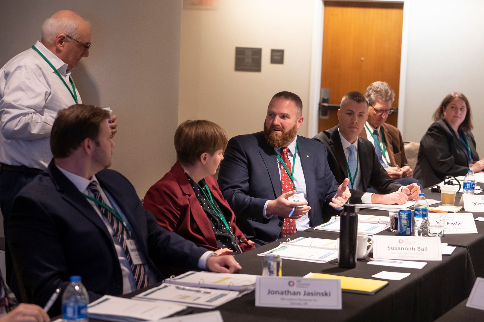 a group of people are sitting at a table having a meeting .