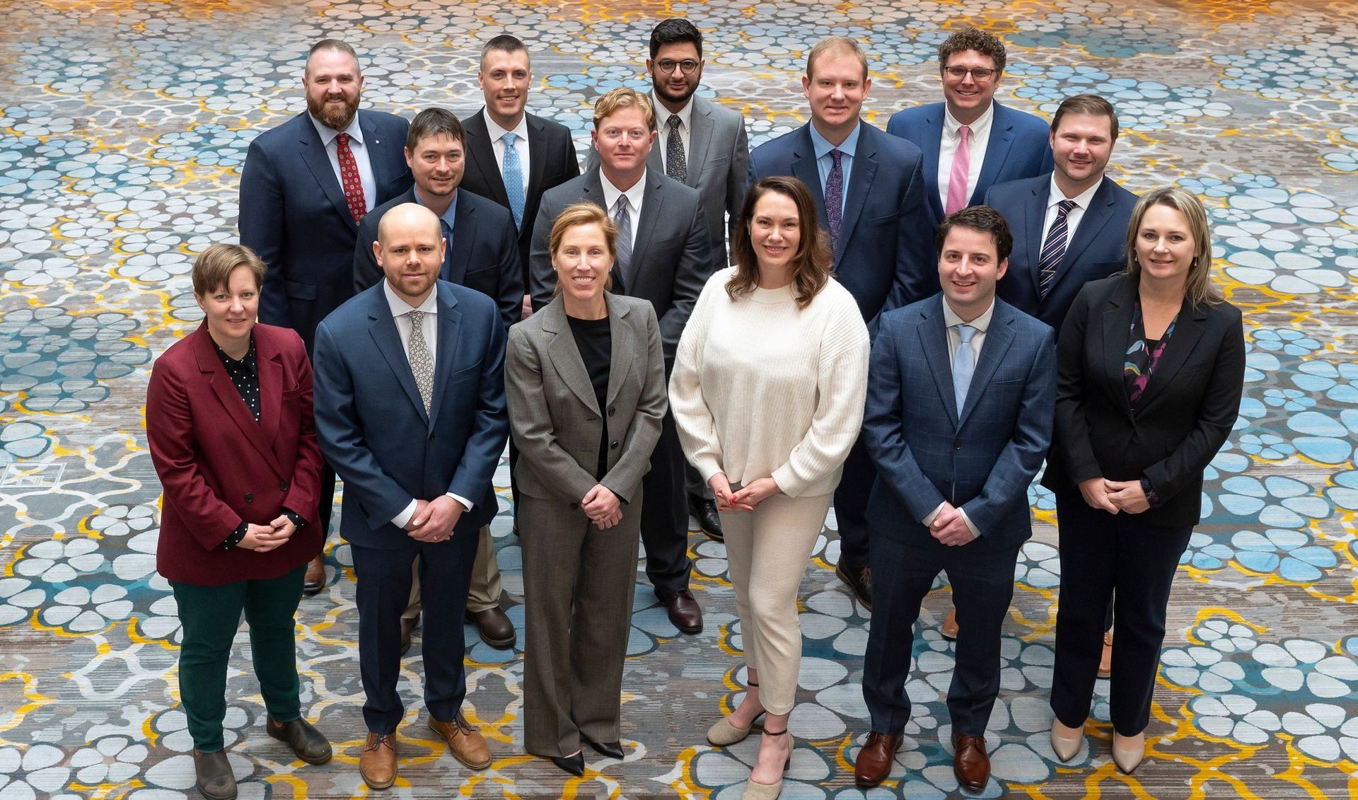 a group of people in suits and ties are posing for a picture .