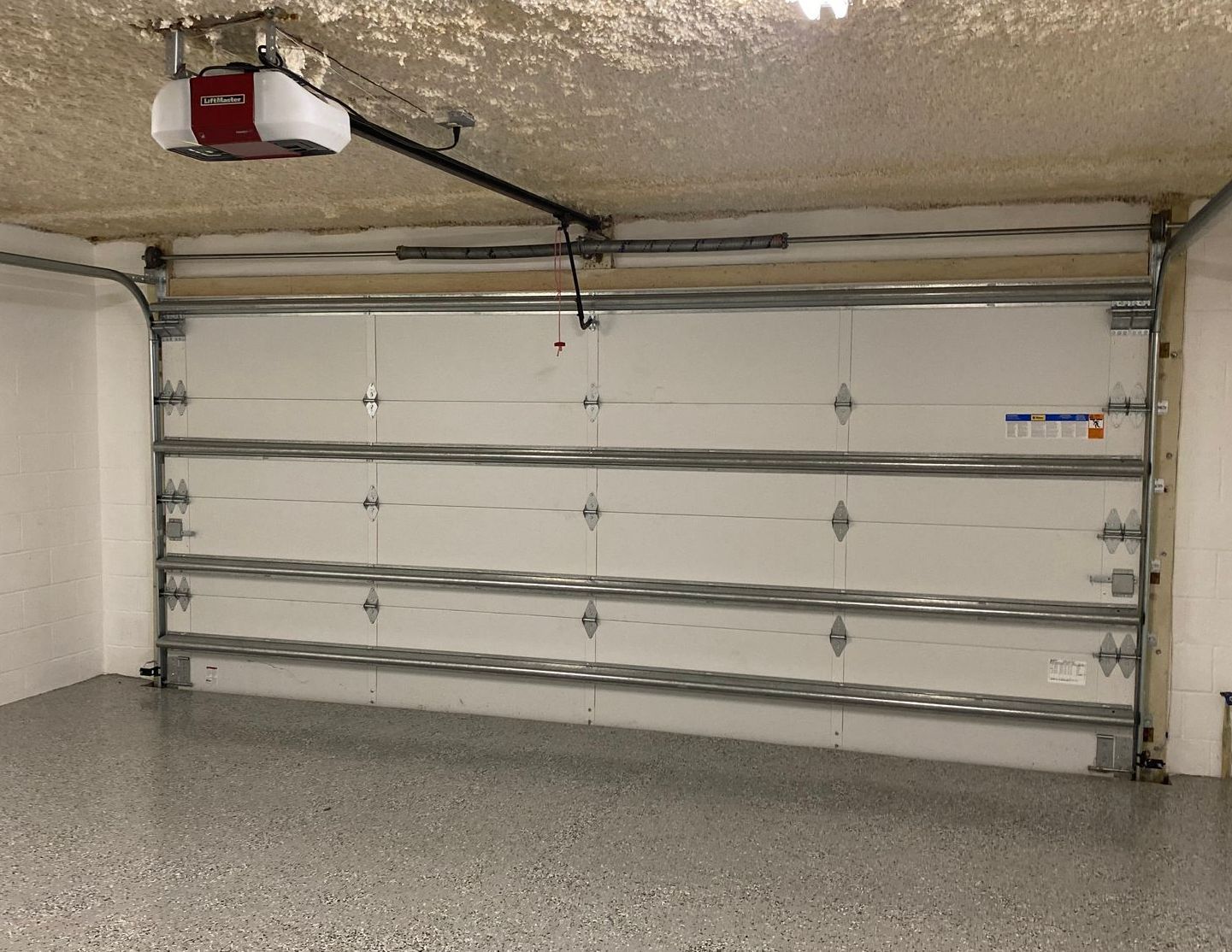 Garage door and opener installation with garage door panels constructed with insulation built internally