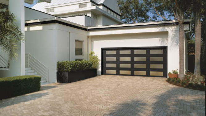 Glass garage door with Bronze glass finish and black steel frame with insulation built internal to the panels in Venice, FL