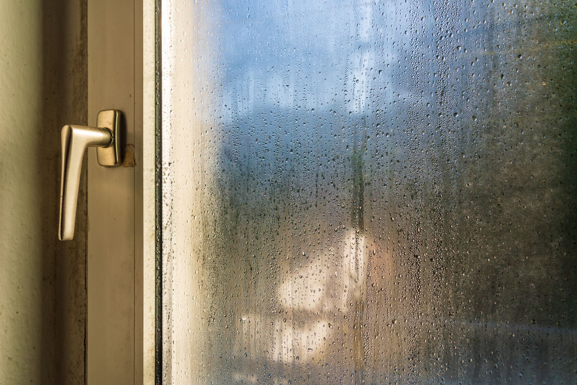 An interior view of droplets of water on a transparent glass door.