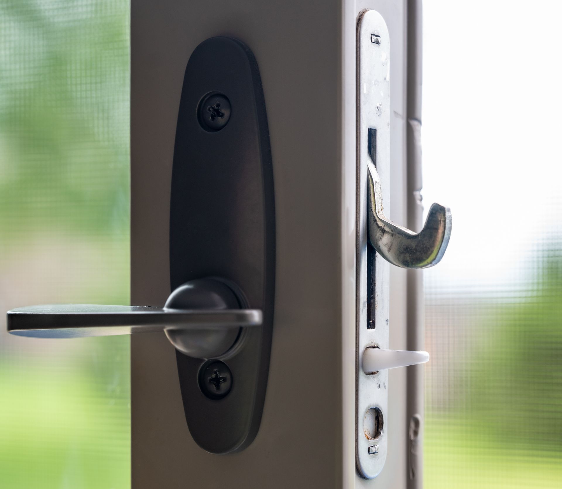 A sliding glass and screen door handle and locking hardware with a jam.