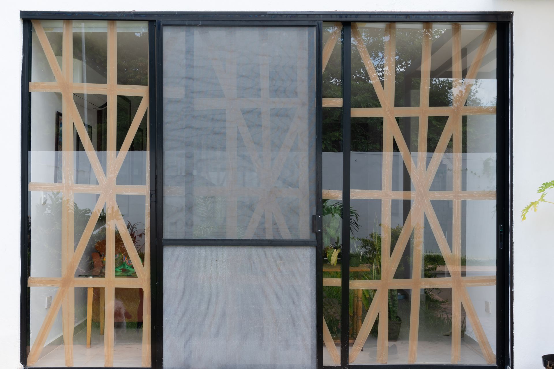 Large sliding glass doors with protective tape patterns, preparing windows. Large sliding glass doors with protective tape patterns, preparing windows.