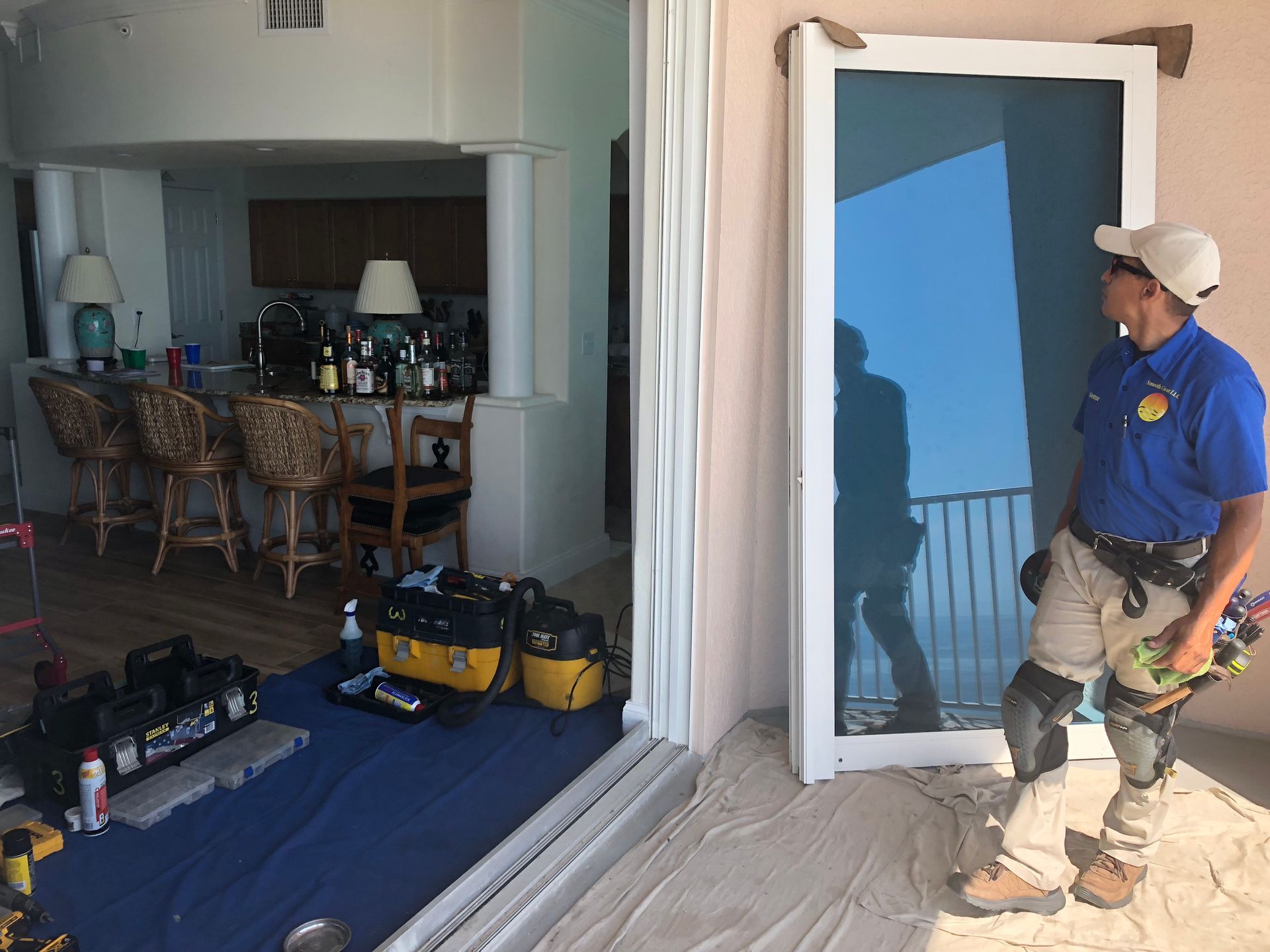 House contractor installs a glass hurricane door on a white house.