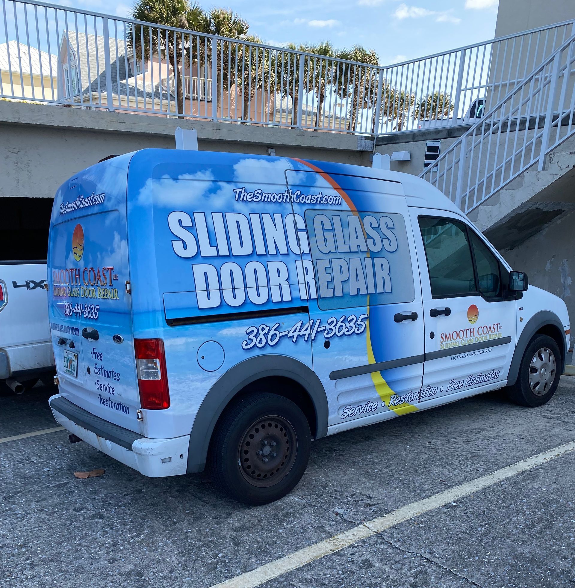 A sliding glass door repair van is parked in a parking lot. A sliding glass door repair van is parked in a parking lot.