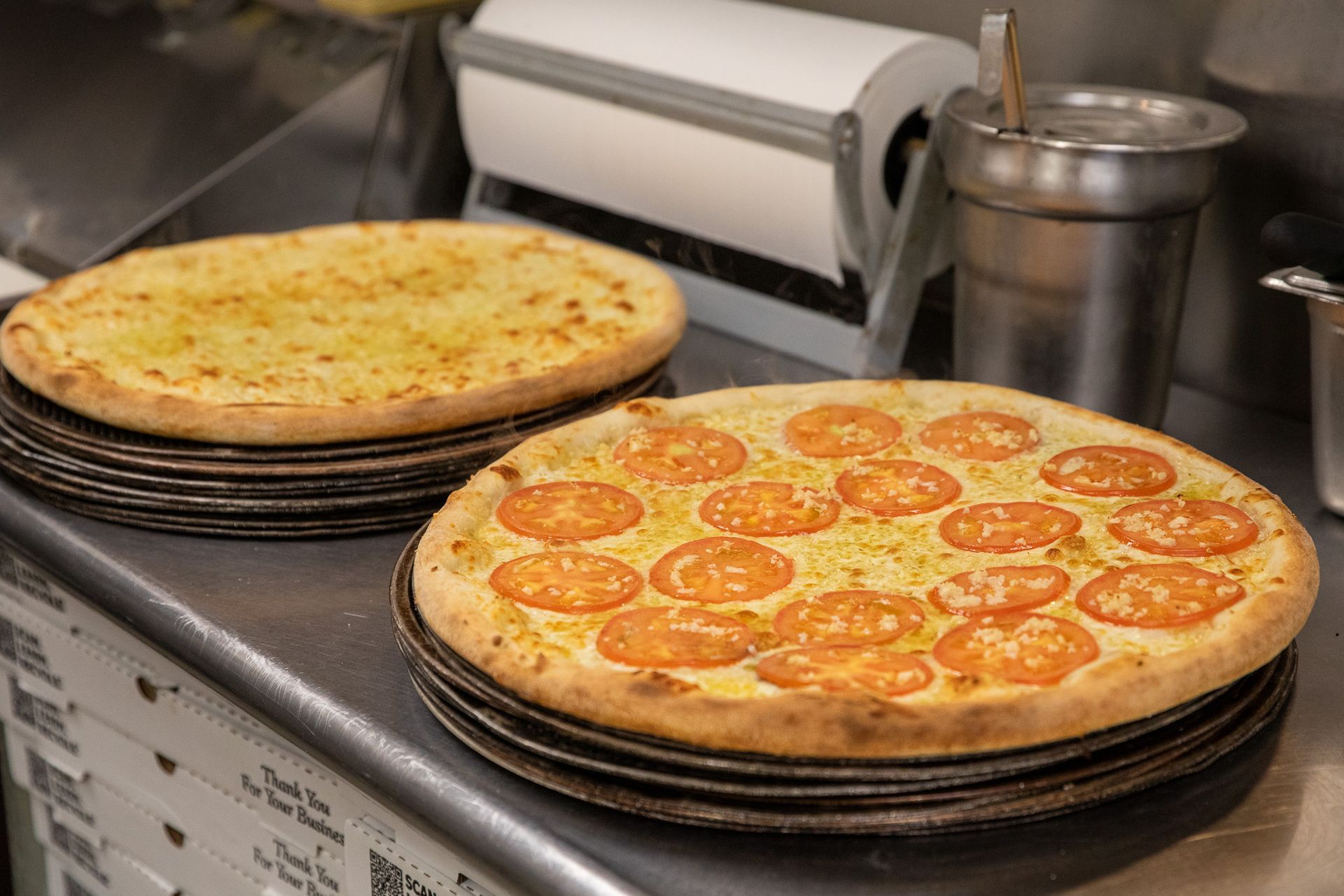 A person is holding a pizza box in front of a bowl of salad.