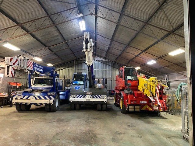 A Warehouse Filled With Lots of Trucks and Cranes — CA Crane Hire in Forest Glen, QLD