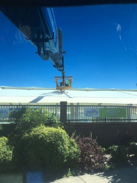 A Crane is Lifting a Sign on Top of a Building — CA Crane Hire in Forest Glen, QLD