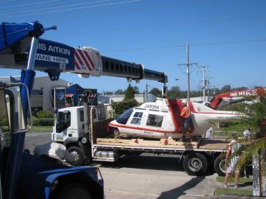 A Helicopter is Being Lifted by a Crane on a Flatbed Truck — CA Crane Hire in Forest Glen, QLD