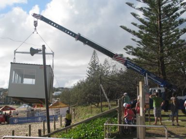 A Crane is Lifting a Container on a Beach — CA Crane Hire in Forest Glen, QLD