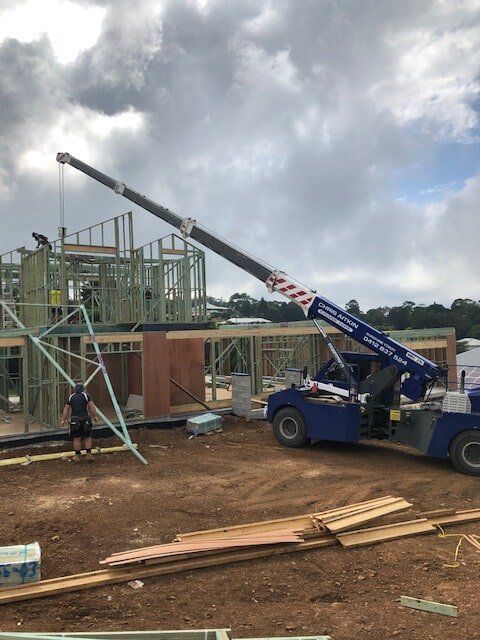 A Crane is Being Used to Lift a Building in a Construction Site — CA Crane Hire in Forest Glen, QLD