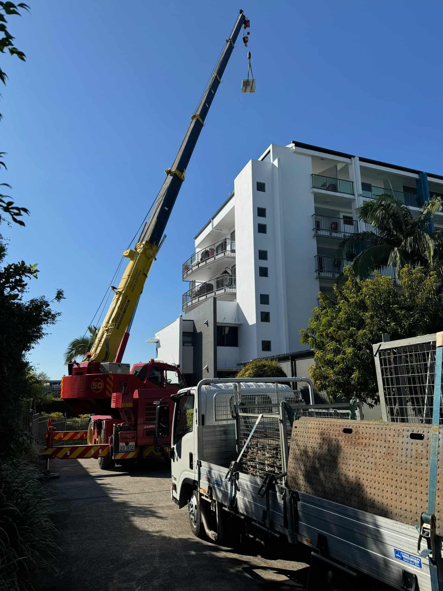 A Truck With A Crane Attached To It Is Parked In Front Of A Building — CA Crane Hire in Forest Glen, QLD