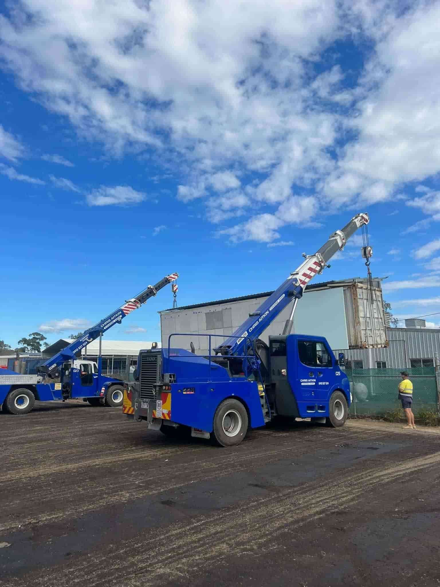 Two Blue Trucks With Cranes Attached To Them Are Parked In A Parking Lot — CA Crane Hire in Forest Glen, QLD