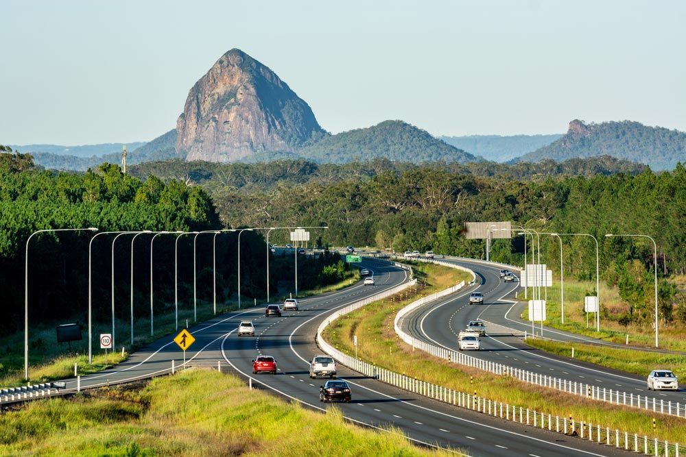 A Highway With a Mountain in the Background and Cars Driving Down it — CA Crane Hire in Beerwah, QLD