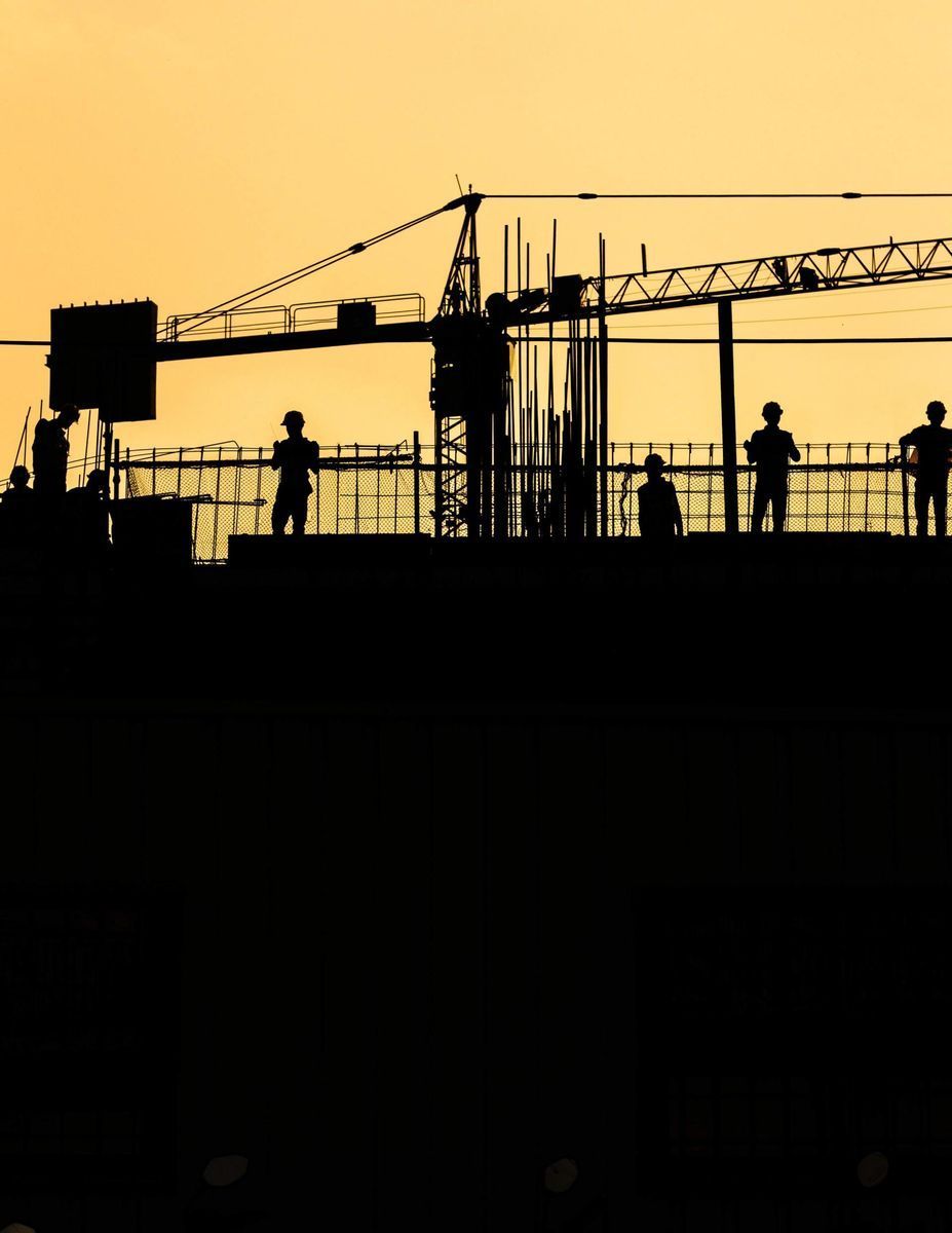 A Group of Construction Workers Are Standing in Front of a Crane — CA Crane Hire in Forest Glen, QLD