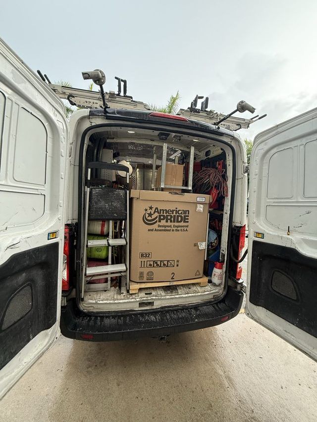 White van open with contents, including a large cardboard box with 