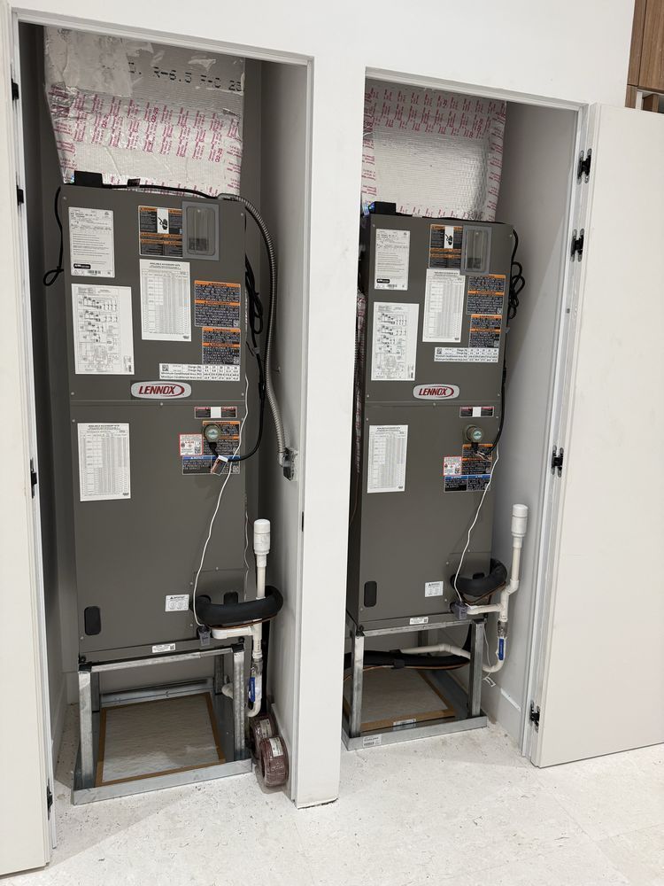 Two Lennox HVAC units in white-walled enclosures with open doors.