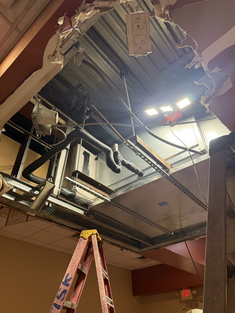 Ceiling damage reveals HVAC system, ladder, and wires.