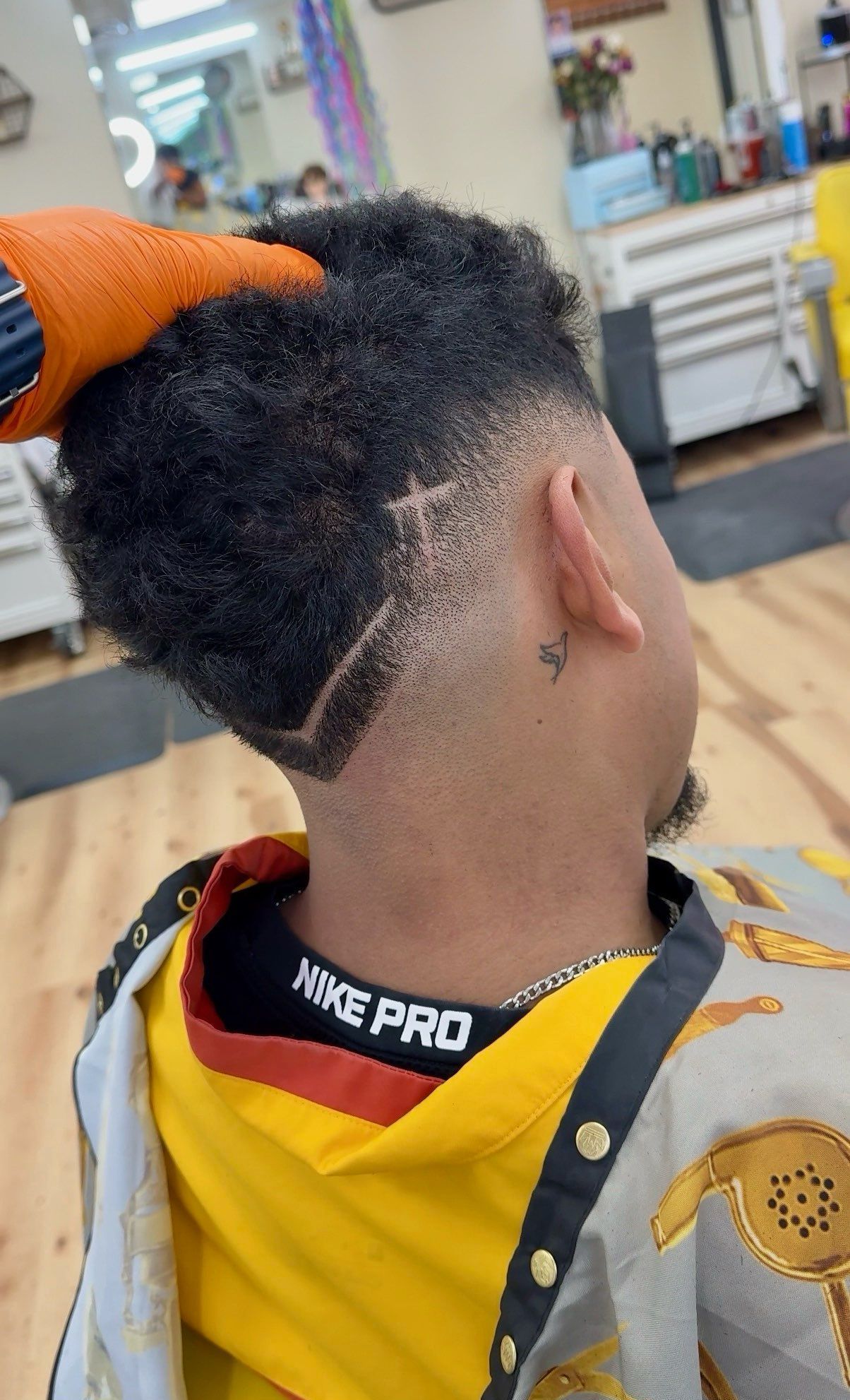 A man with a beard is getting his hair cut at a barber shop.