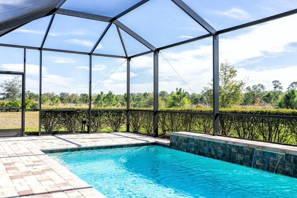 There Is A Swimming Pool In The Backyard With A Screened In Area — Datco Windows & Doors Pty Ltd In Casino, NSW
