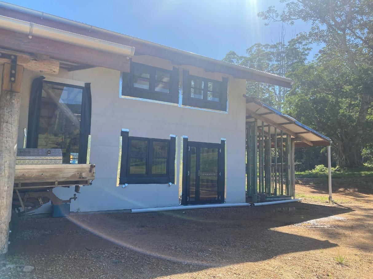 A White House With A Lot Of Windows And Doors Is Being Built — Datco Windows & Doors Pty Ltd In Tweed Coast, NSW