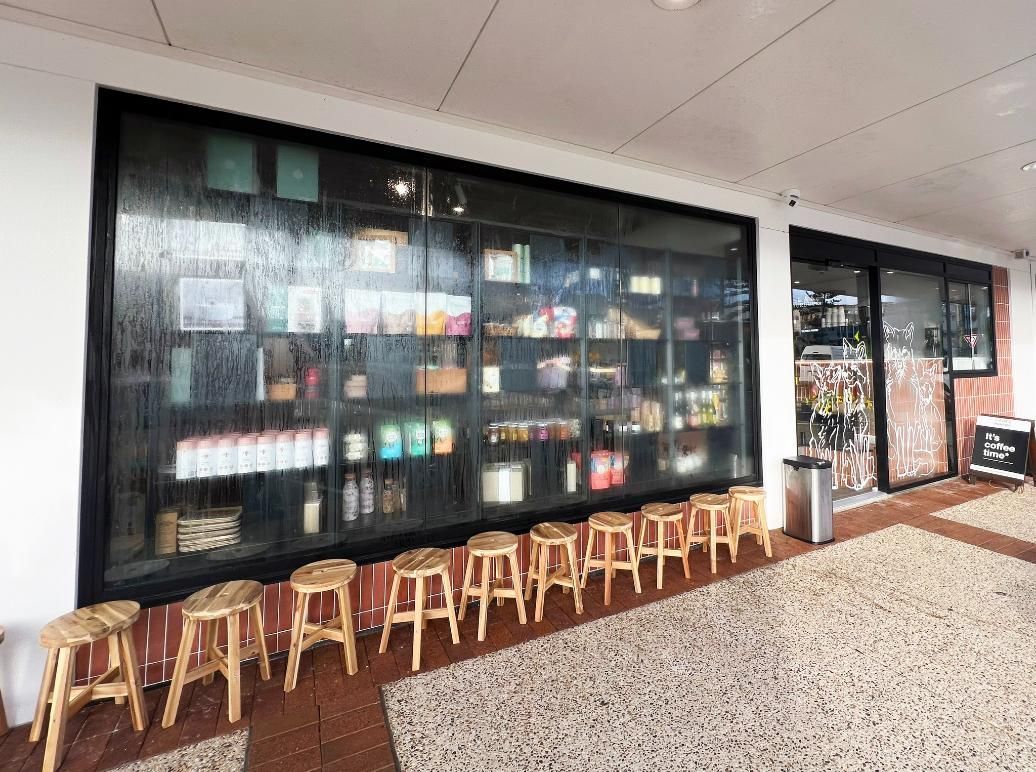 A Row Of Wooden Stools Are Lined Up In Front Of A Store — Datco Windows & Doors Pty Ltd In South Murwillumbah, NSW