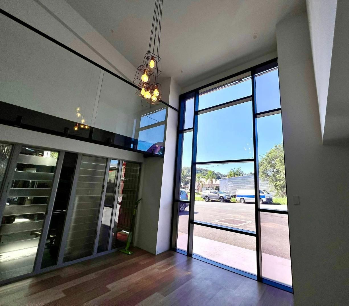 A Room With A Lot Of Windows And A Chandelier Hanging From The Ceiling — Datco Windows & Doors Pty Ltd In South Murwillumbah, NSW