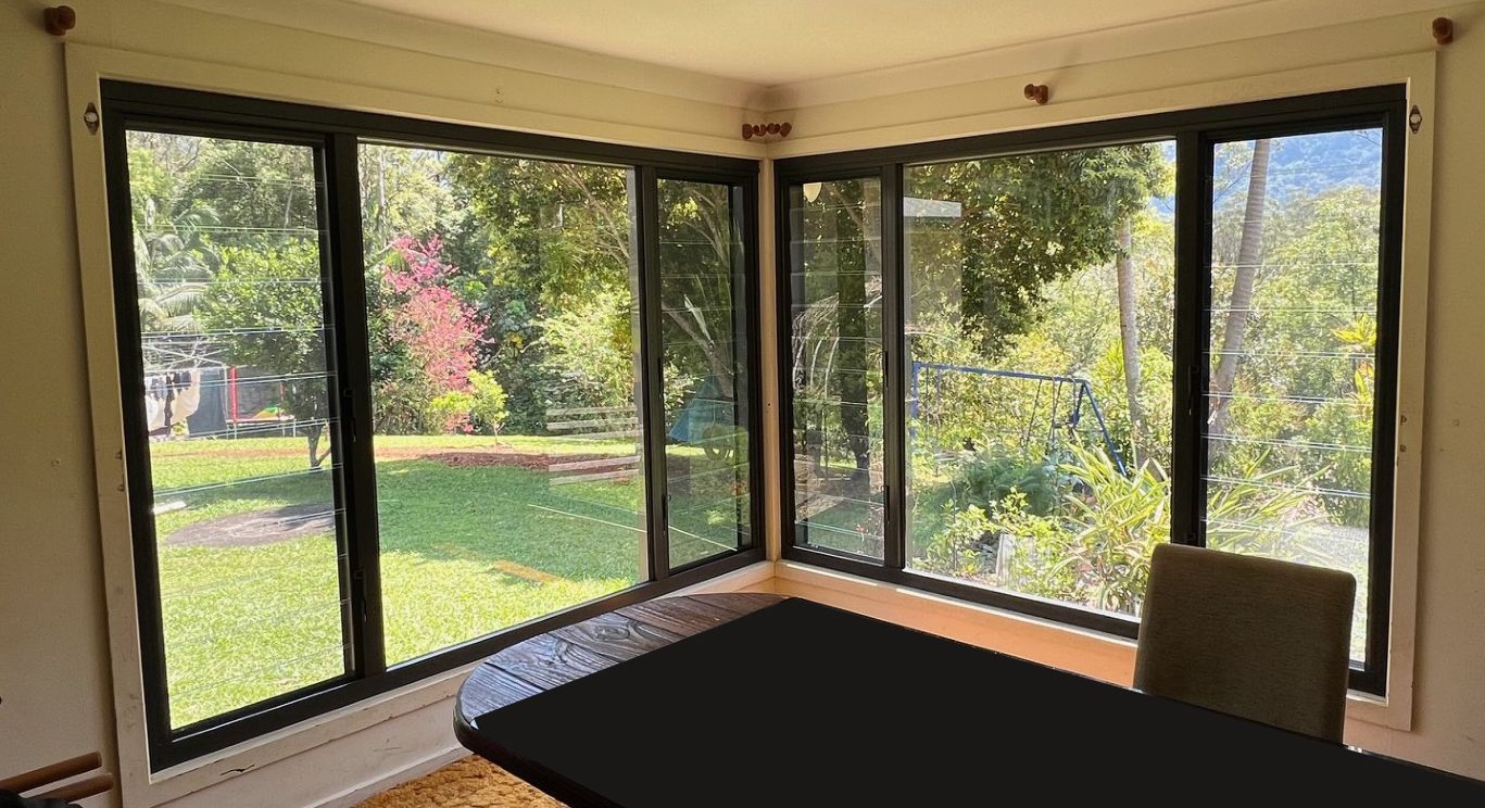 Corner Room With Large Black-framed Windows Overlooking a Green Yard — Datco Windows & Doors Pty Ltd In South Murwillumbah, NSW